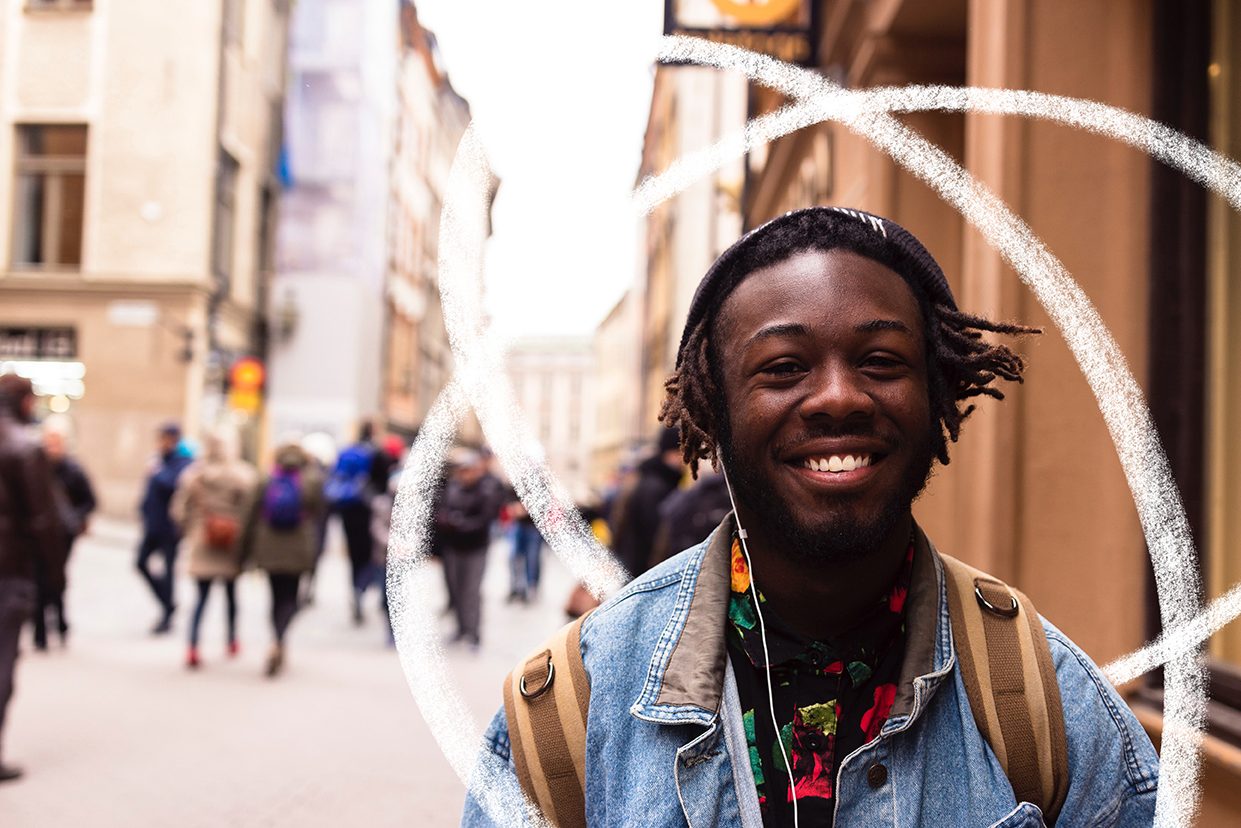 Smiling younger man walking down a street