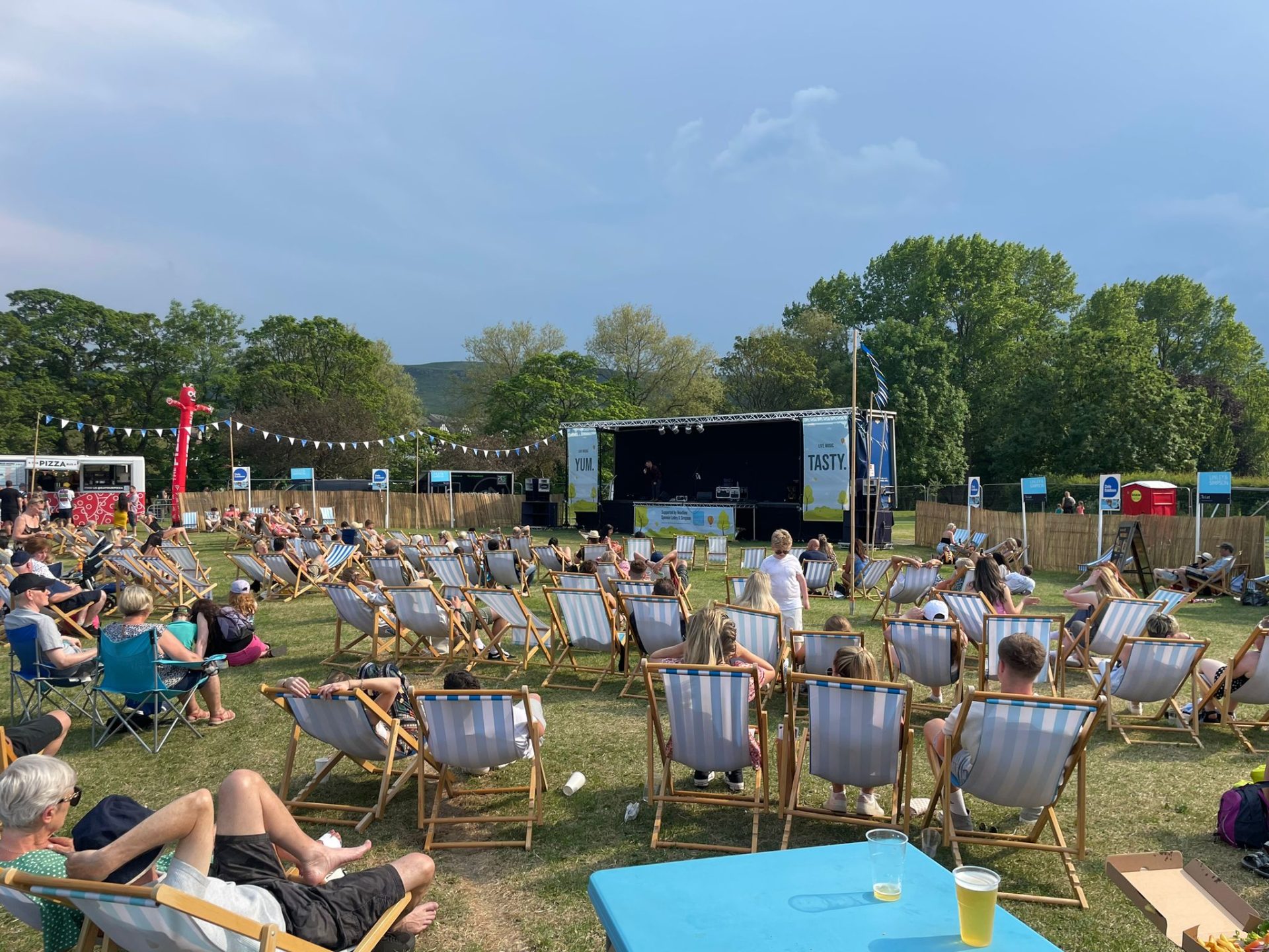 People sitting in deck chairs facing a stage